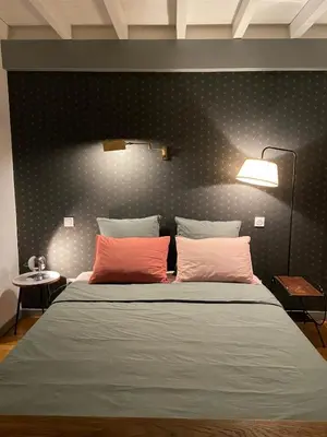 a bedroom with a large bed with a black wall at Le jardin du Griffoul in Nébias