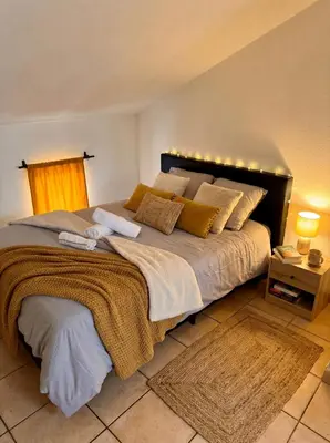 a bedroom with a large bed with lights on it at Bel Appartement Climatisé avec Terrasse au centre-ville de Narbonne in Narbonne