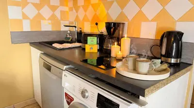 a kitchen with a counter top with cups on it at Bel Appartement Climatisé avec Terrasse au centre-ville de Narbonne in Narbonne