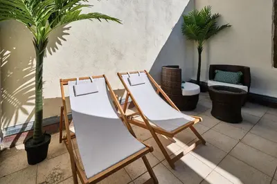 two chairs and a table in a room with plants at Bel Appartement Climatisé avec Terrasse au centre-ville de Narbonne in Narbonne