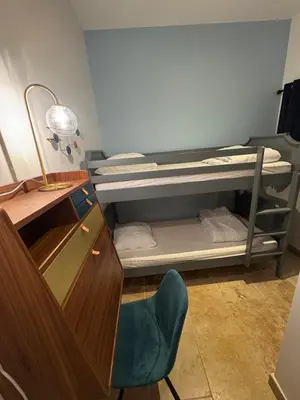 a room with a bunk bed with a chair and a desk at Charmant appartement au cœur historique de Narbonne in Narbonne
