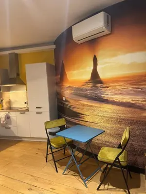 a table and chairs in a kitchen with a painting on the wall at Charmant appartement au cœur historique de Narbonne in Narbonne