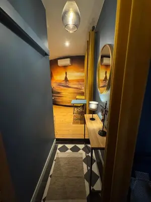 a hallway with a painting of the ocean and a table at Charmant appartement au cœur historique de Narbonne in Narbonne