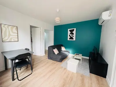 a living room with a couch and a table and a chair at Maison indépendante l Climatisation l Extérieur in Castres