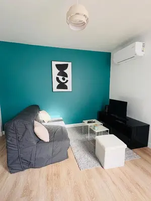 a living room with a couch and a blue wall at Maison indépendante l Climatisation l Extérieur in Castres