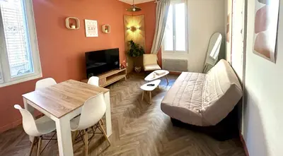 a living room with a table and a dining room at Jolie 2 pièces avec terrasse au centre-ville, proche gare in Narbonne