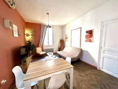 a living room with a table and a couch at Jolie 2 pièces avec terrasse au centre-ville, proche gare in Narbonne