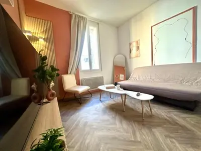 a bedroom with a bed and a couch and a table at Jolie 2 pièces avec terrasse au centre-ville, proche gare in Narbonne