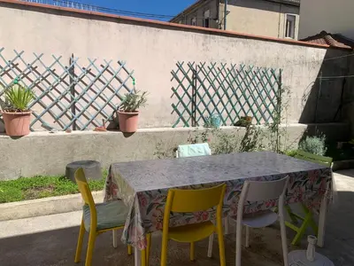 a table with four chairs and a table and a fence at Chambres d hôtes H in Lavelanet