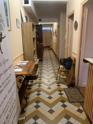 a hallway with a checkerboard floor in a store at Chambres d hôtes H in Lavelanet