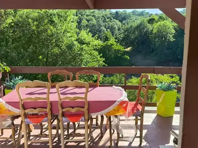 a pink table and chairs on a balcony with a view at maison chalet in Bessède-de-Sault