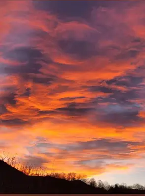 a sunset with a cloudy sky above a hill at maison chalet in Bessède-de-Sault