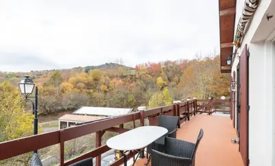 a balcony with a table and chairs and trees at maison chalet in Bessède-de-Sault