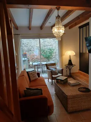 a living room with a couch and a chandelier at La route des vignes in Val-de-Dagne