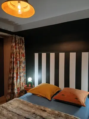 a bedroom with a bed with a black and white headboard at La route des vignes in Val-de-Dagne