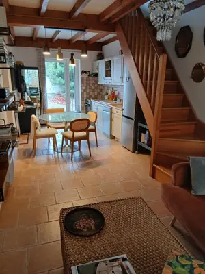 a kitchen and living room with a table and chairs at La route des vignes in Val-de-Dagne