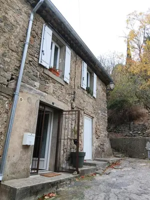 a stone house with a door and a window at La route des vignes in Val-de-Dagne
