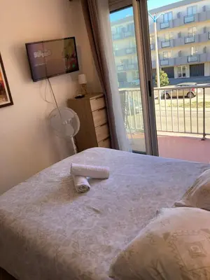 a bedroom with a bed and a large window at T2 tout confort - Mer à 200 m in Port-la-Nouvelle