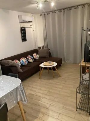 a living room with a couch and a table at T2 tout confort - Mer à 200 m in Port-la-Nouvelle