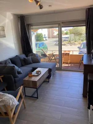 a living room with a blue couch and a table at T2 tout confort - Mer à 200 m in Port-la-Nouvelle