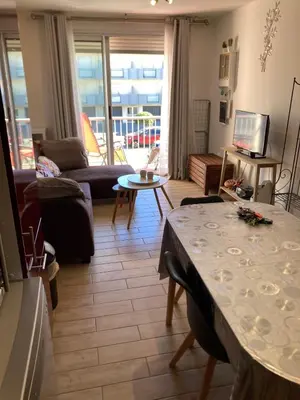 a living room with a table and a couch at T2 tout confort - Mer à 200 m in Port-la-Nouvelle