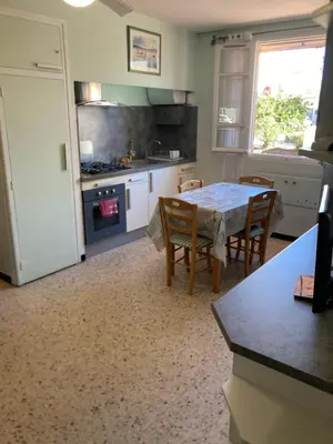 a kitchen with a table and chairs in a room at T1 - Centre ville rez-de-chaussée in Port-la-Nouvelle