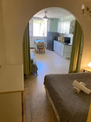 a room with two beds and a kitchen with a table at T1 - Centre ville rez-de-chaussée in Port-la-Nouvelle