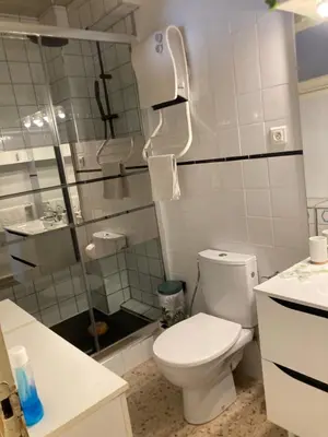 a bathroom with a toilet and a glass shower at T1 - Centre ville rez-de-chaussée in Port-la-Nouvelle
