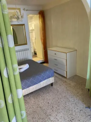 a bedroom with a bed and a dresser and a mirror at T1 - Centre ville rez-de-chaussée in Port-la-Nouvelle