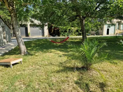 a hammock in a park next to a tree at Cottage with large garden in Rieumajou