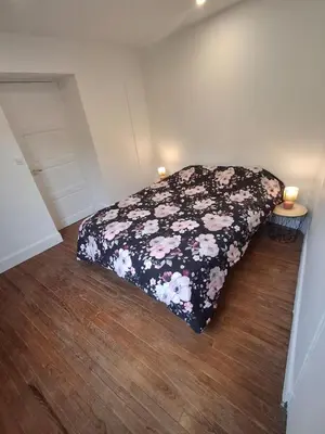 a bedroom with a bed with a floral bedspread at T2 Au pied de la passerelle in Mazamet