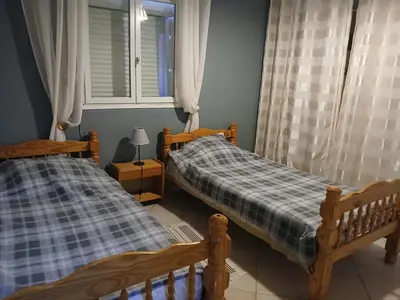 two twin beds in a room with a window at Appartement 2 pièces petit village au calme in Moussoulens