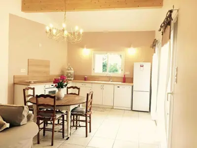 a kitchen with a table and a kitchen with a refrigerator at Le gîte d 'Anaïs in La Redorte