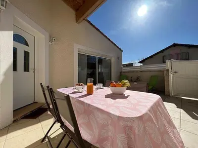 a table with a bowl of fruit on a patio at Le gîte d 'Anaïs in La Redorte