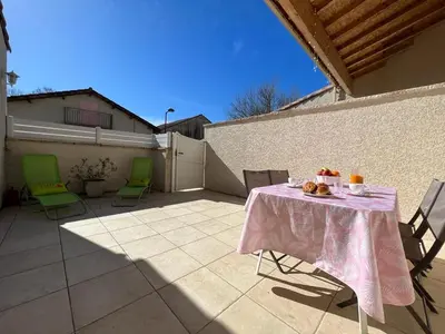 a table and chairs on a patio with a pink table cloth at Le gîte d 'Anaïs in La Redorte