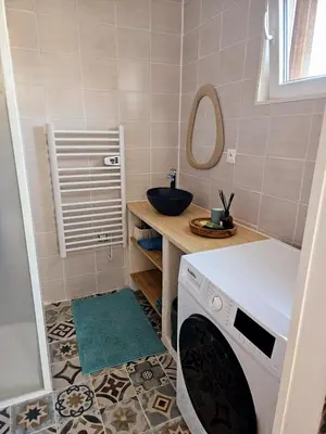 a bathroom with a sink and a washing machine at Studio Conteneur in Cruscades