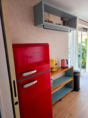 a red refrigerator in a kitchen with a shelf at Studio Conteneur in Cruscades