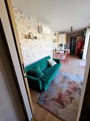 a green couch sitting in a living room at Studio Conteneur in Cruscades
