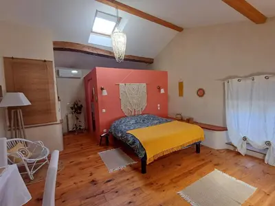 a bedroom with a bed in a room with wooden floors at SAINT-JULIA - Studio in Saint-Julia