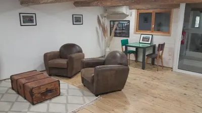 a living room with two chairs and a table at La commanderie in Homps