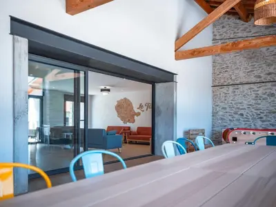 a room with a table and chairs and a living room at La Borie Lautrecoise - 26 pers - Piscine chauffée & Clim in Jonquières