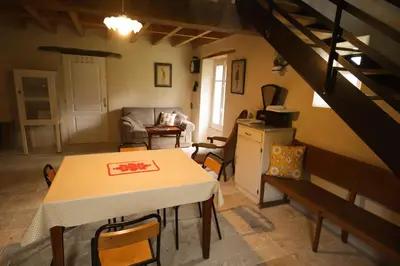 a kitchen and living room with a table and chairs at Le Refuge de Bruno in Saint-Amans-Soult