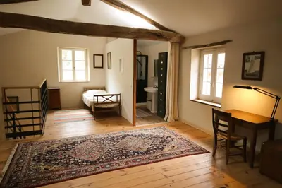 a living room with a table and a rug at Le Refuge de Bruno in Saint-Amans-Soult