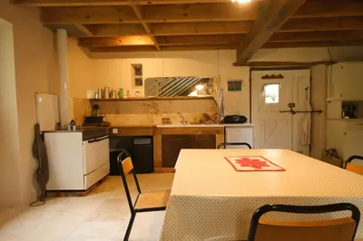 a kitchen with a table and a table and chairs at Le Refuge de Bruno in Saint-Amans-Soult