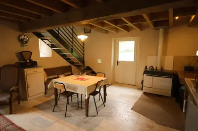 a kitchen with a table and chairs in a room at Le Refuge de Bruno in Saint-Amans-Soult