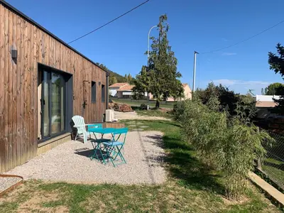 a patio with a table and chairs next to a building at Studio Cosy en Conteneur-Maritime in Tabre