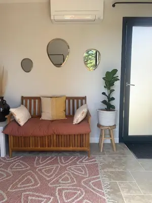 a couch in a living room with a potted plant at Studio Cosy en Conteneur-Maritime in Tabre