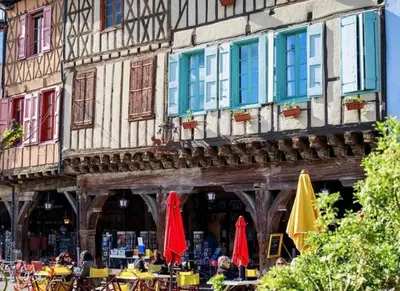 a building with tables and umbrellas in front of it at Studio Cosy en Conteneur-Maritime in Tabre