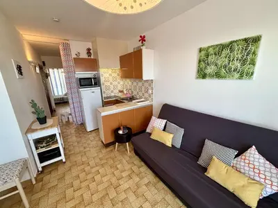 a living room with a couch and a kitchen at Appartement 2 pièces - 5 couchages Port la Nouvelle PN440-023 in Port-la-Nouvelle