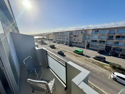 a balcony with a chair and a view of a building at Appartement 2 pièces - 5 couchages Port la Nouvelle PN440-023 in Port-la-Nouvelle